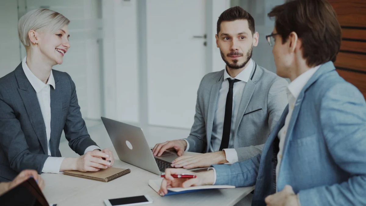 Ba đồng nghiệp xem máy tính trong cuộc trao đổi tại văn phòng
