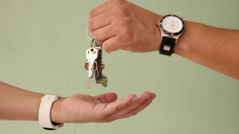 Một bàn tay trao chùm chìa khóa cho bàn tay đang đón nhận